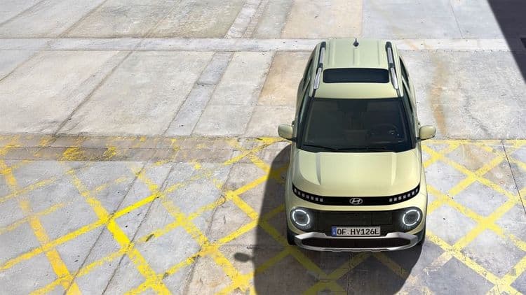 Hyundai INSTER in beige auf einem Parkplatz.