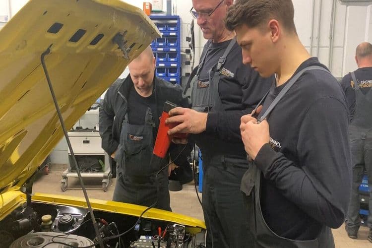 Mekatronik mühendisleri ve stajyerler Lancer motoru üzerinde çalışıyor