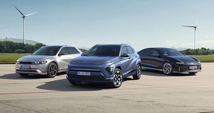 Hyundai IONIQ 5, Hyundai KONA Elektro und Hyundai IONIQ 6 stehen am Feld mit Windrädern