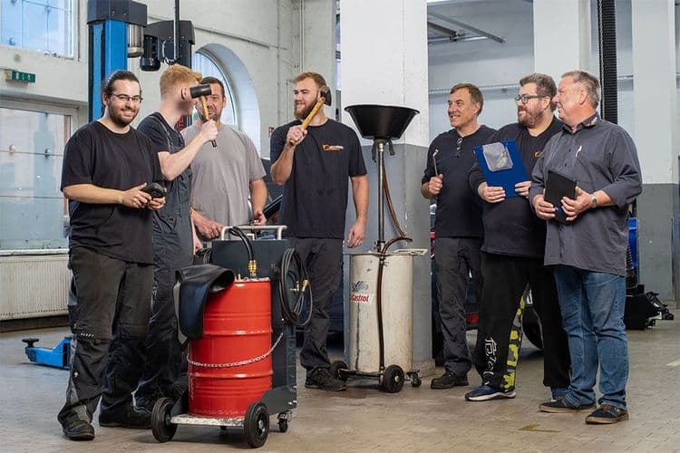 7 werkstatt mitarbeiter mit werkzeug in der hand lachen zusammen