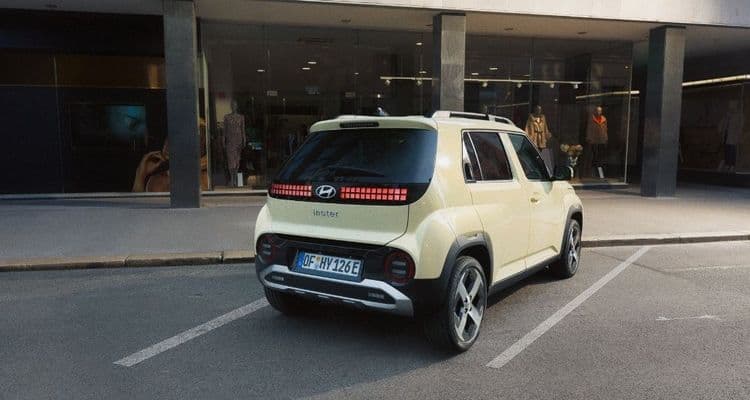 Hyundai INSTER parkt vor einem Haus.