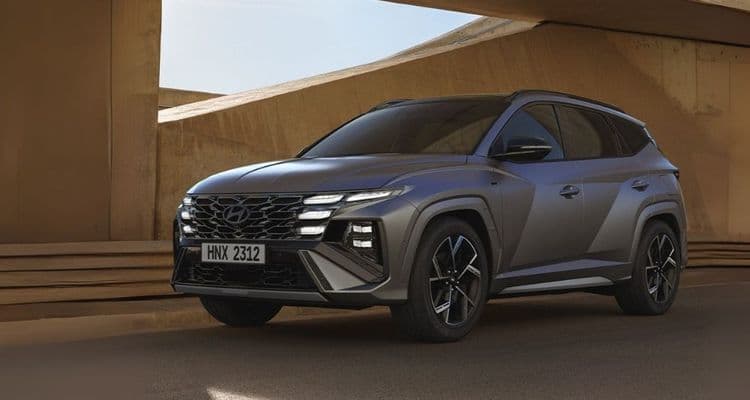 Ein Hyundai TUCSON in Grau steht vor einem modernen Gebäude.
