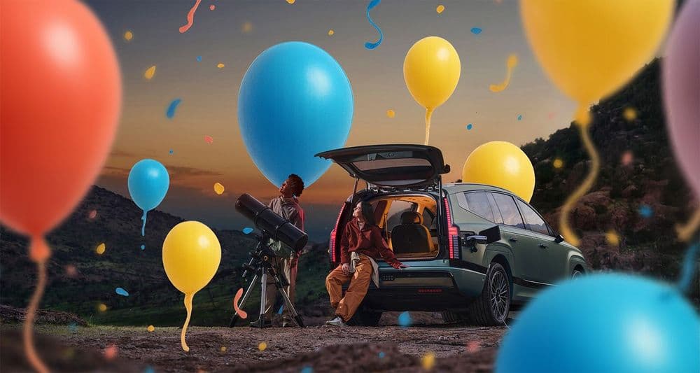 Hyundai IONIQ 9 steht in der Natur. Im Vor- und Hintergrund befinden sich Ballons.
