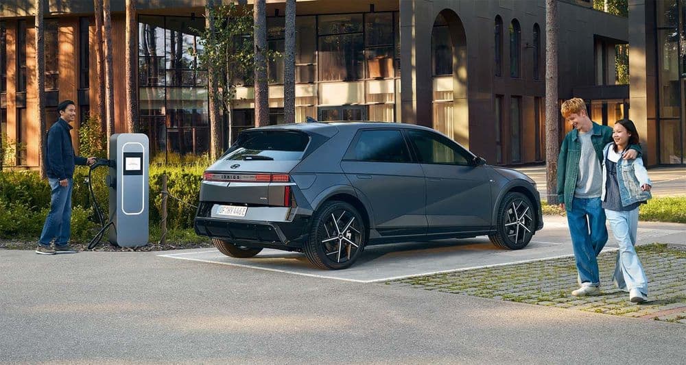 Ioniq 5, black exterior, rear view in the woods in front of a villa