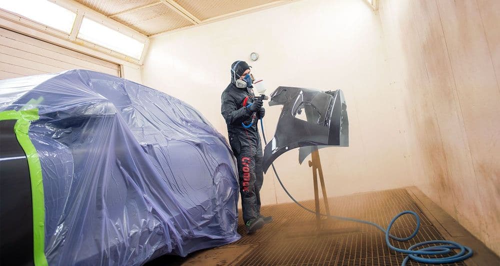 Pintor realiza trabajos de pintura de vehículos.