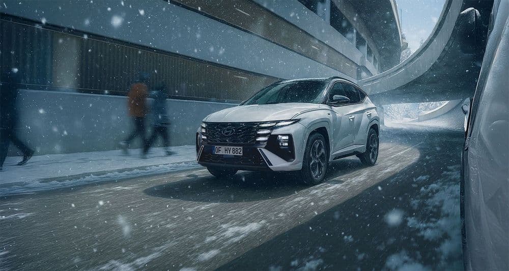Ein Hyundai TUCSON fährt durch eine Winterlandschaft.